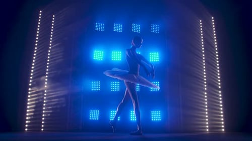 Elegant Ballerina Posing in Blue Stage Lights