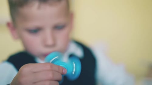 Petit garçon regarde tourner Spinner sur fond flou