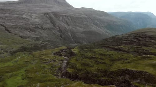 Aerial view of a rocky and very rugged mountain range with sparse vegetation