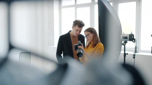 Girl and Guy Model Talking in Photo Studio Watching Pictures on Digital Camera
