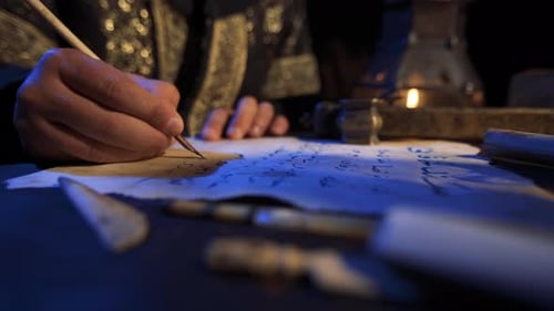 Person Writing with Quill Pen in Candlelight