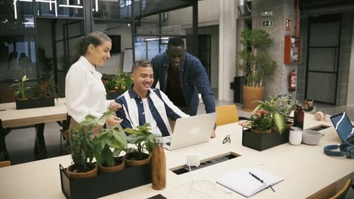 Colegas multirraciais navegando juntos no laptop