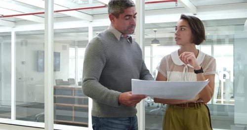Business people discussing over document in modern office
