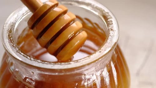 Honey Is Dripping From the Wooden Spoon
