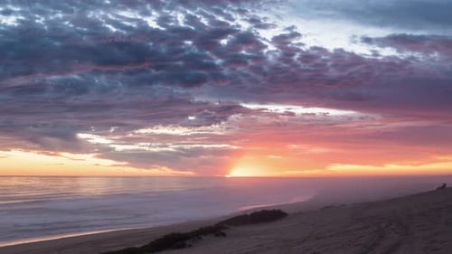 Colorful Sunset with Bloody Sky and Red Clouds over Ocean Coast Beach in Summer Evening