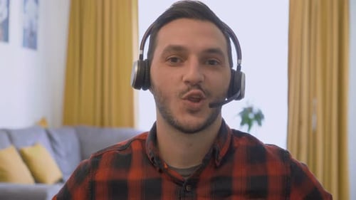 Young Man Talking Wearing Headphones Indoors