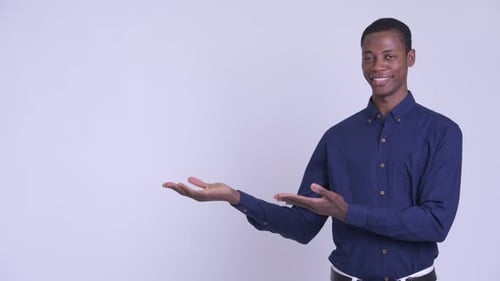 Smiling Young Adult Man Presenting with Open Hands