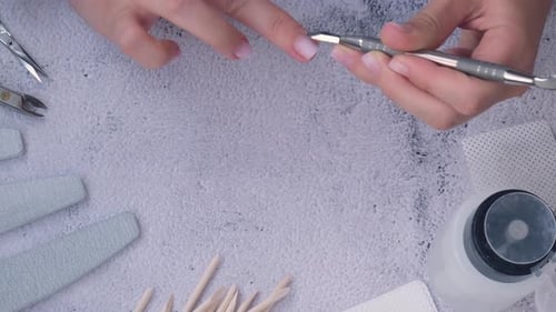 Woman Doing Manicure With Tools and Supplies