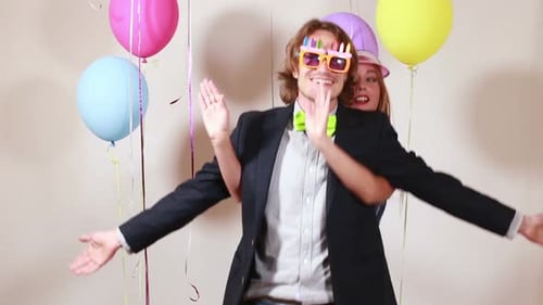 Cheerful couple dancing funny in photo booth