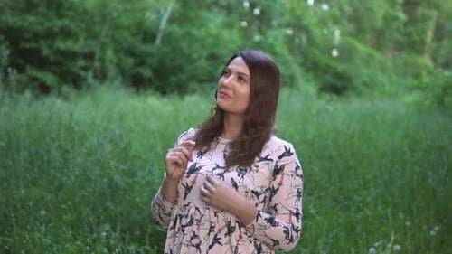 A Beautiful Girl Stands in the Forest with Summer Sunny Weather