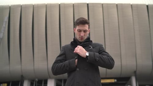 Young Adult Man in Coat Buttons Up Outside