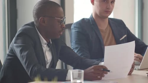 Businessmen Working Together at Table in Office