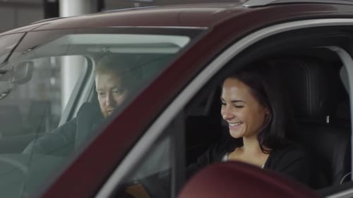 Car Dealer Giving Consultation to Female Customer in Auto Showroom