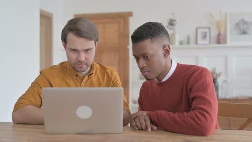 Men Celebrating Teamwork Success Using Laptop At Home