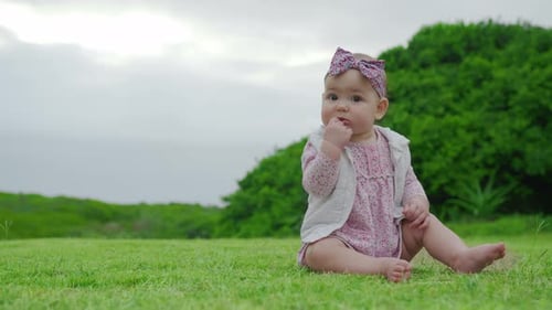 Porträt von niedlichem Baby Mädchen Kleinkind Mädchen im Freien, das Grashalm isst
