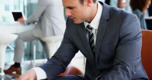 Man Working on Laptop and Taking Phone Call