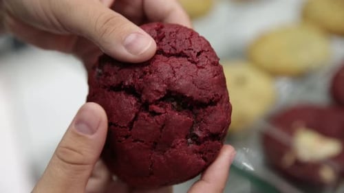 Breaking open a freshly backed red velvet cookie to show the gooey melted chocolate inside - close u