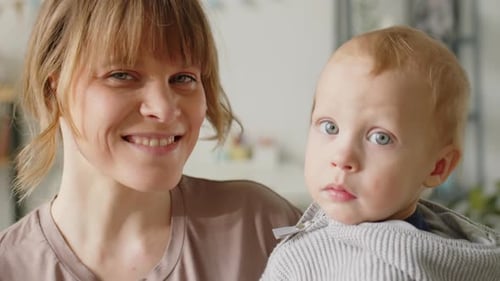 Smiling Woman Holding Baby Indoors