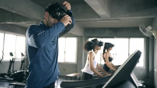 4K Athletic man and woman wearing VR glasses jogging exercise on treadmill at fitness gym.