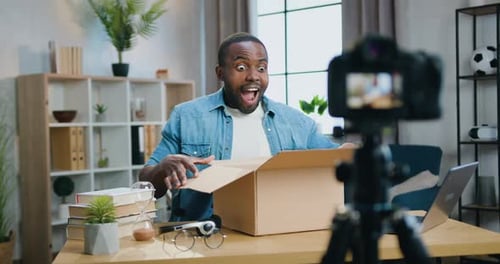 Man Unboxing Delivery Package at Desk Indoors