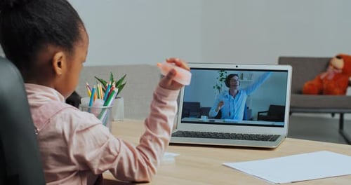 Child Learning Remotely on Laptop with Instructor