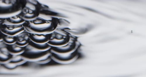 Silver Coloured Bubbles Rising and Floating on the Surface of Water