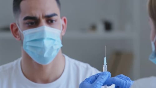 Young Man Declining Injection at Medical Office