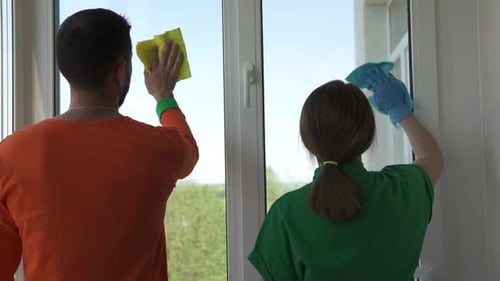 Arbeiter einer professionellen Reinigungsfirma waschen Fenster.