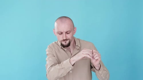 Man Warming Up Hands on Blue Background