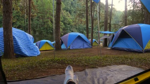 POV Camping Woman Lying in Tent Close Up View on Camp with Many Tents