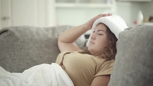 Side View of Ill Plus-size Caucasian Woman Taking Pill in Blister Pack From Hand of Unrecognizable