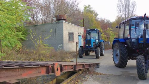 Tractors Parked on Concrete Lot Next to Each Other