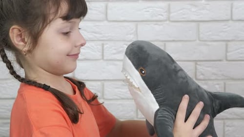 Girl Hugs Soft Toy Shark in Home Setting
