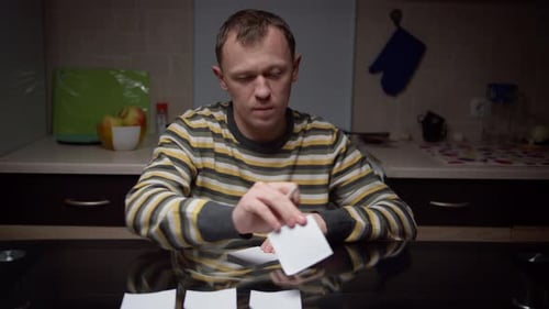 A man writes down plans on sticky notes, lays them in front of himself, business planning