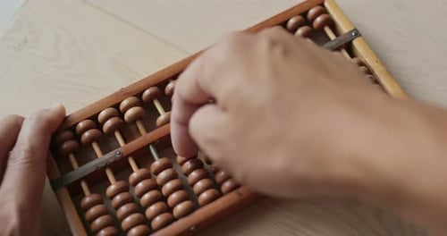 Hands Using an Abacus for Calculations