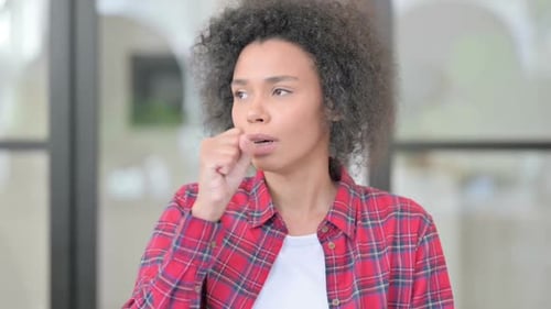 Young Adult Woman Coughing into Fist