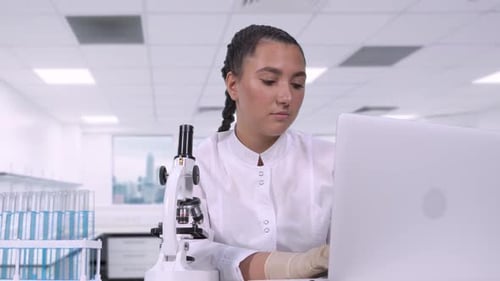 Woman Scientist Using Microscope in a Lab