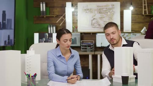 Two Young Architects Working on Urban Plan for Office Buildings