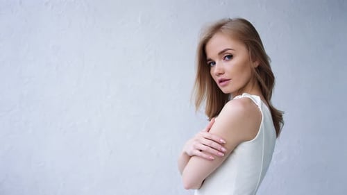 Elegant Woman Posing in White Dress in Studio