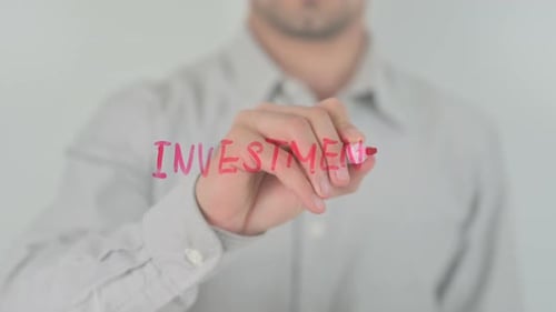 Person Writes Investment on Transparent Surface