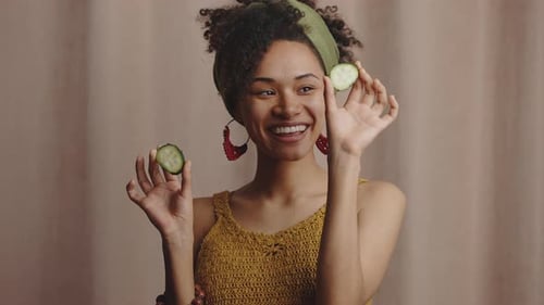 Cheerful Woman Plays with Cucumber Slices