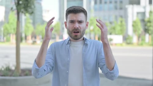 Upset Young Adult Man Shouting Outdoors