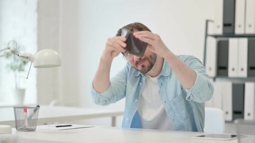 Junger Mann überprüft leere Brieftaschenarbeit