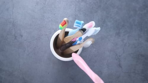 Toothbrushes in a Cup Added to by Hand