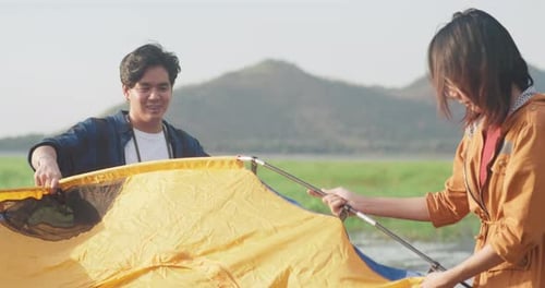 Couple Building Camping Tent in Rural Setting