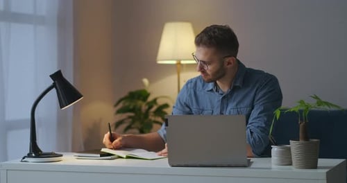 Young Adult Working at Desk at Night