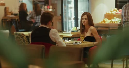 Beautiful Married Couple is Sitting in a Restaurant and Talking