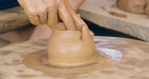 Hands Shaping Clay on Spinning Pottery Wheel