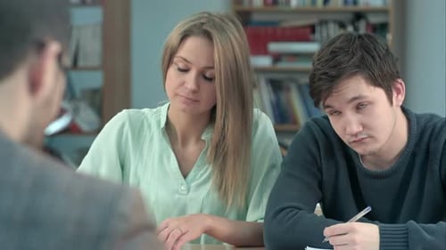 Group of Young Students Writing Something in Their Note Pads While Sitting in a Row