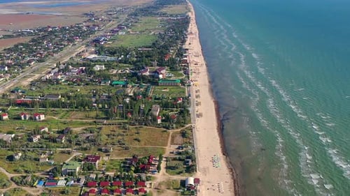 Beautiful flight in summer over the beach. People are resting near the sea.
